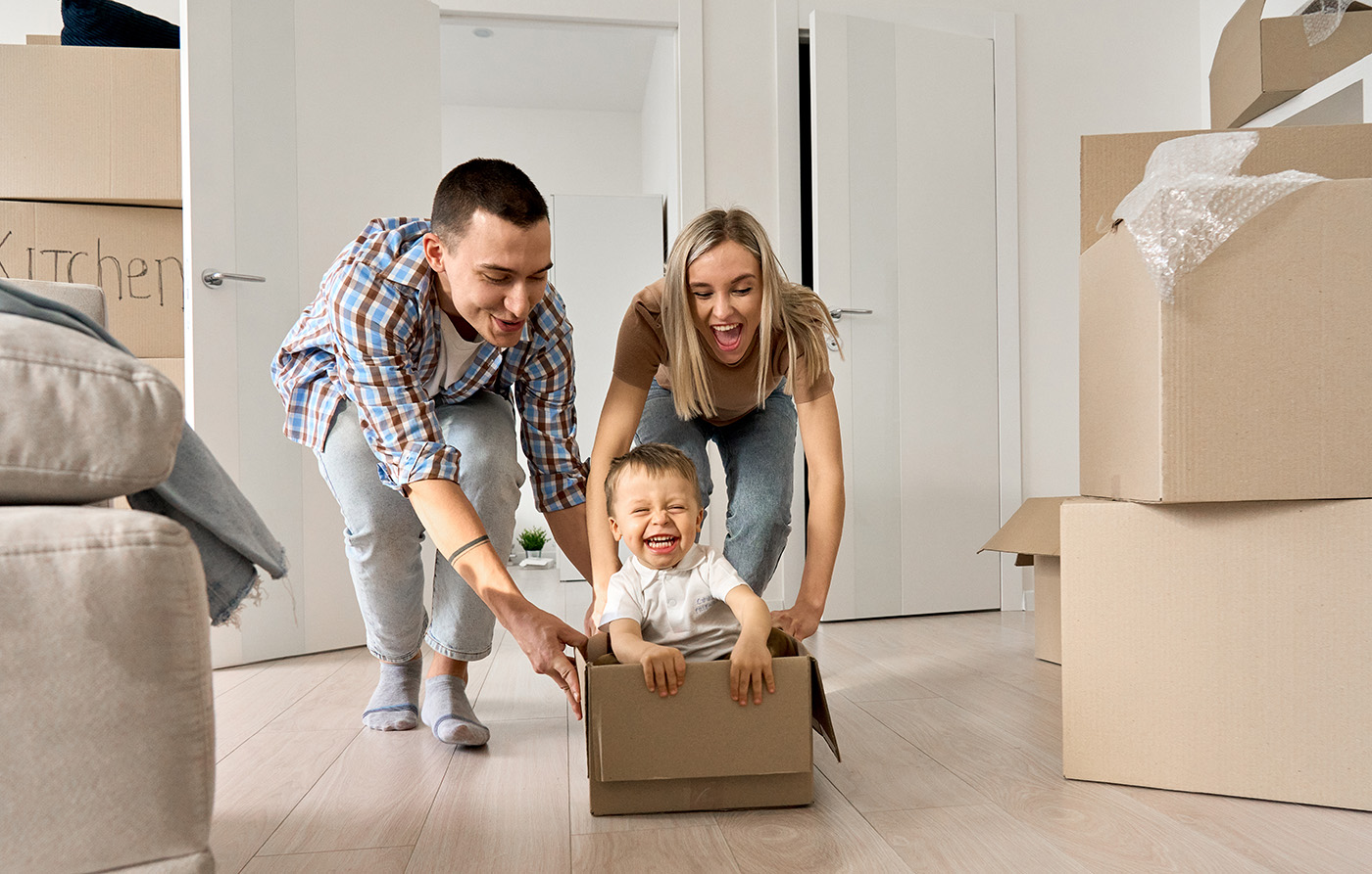 happy-young-parents-pushing-carton-box-with-kid-in-2021-09-02-15-13-28-utc